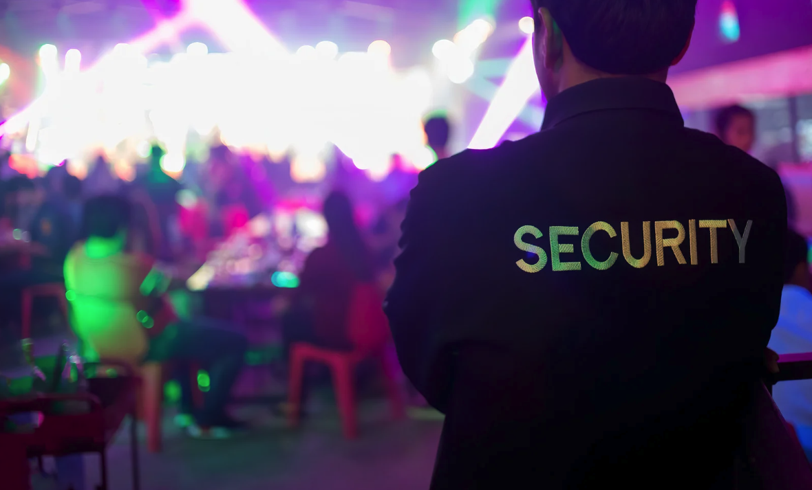 Profissionais de segurança monitorando evento conforme regulamentações legais